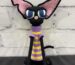Handmade crochet black sphynx cat plush wearing glasses and a purple and yellow striped sweater