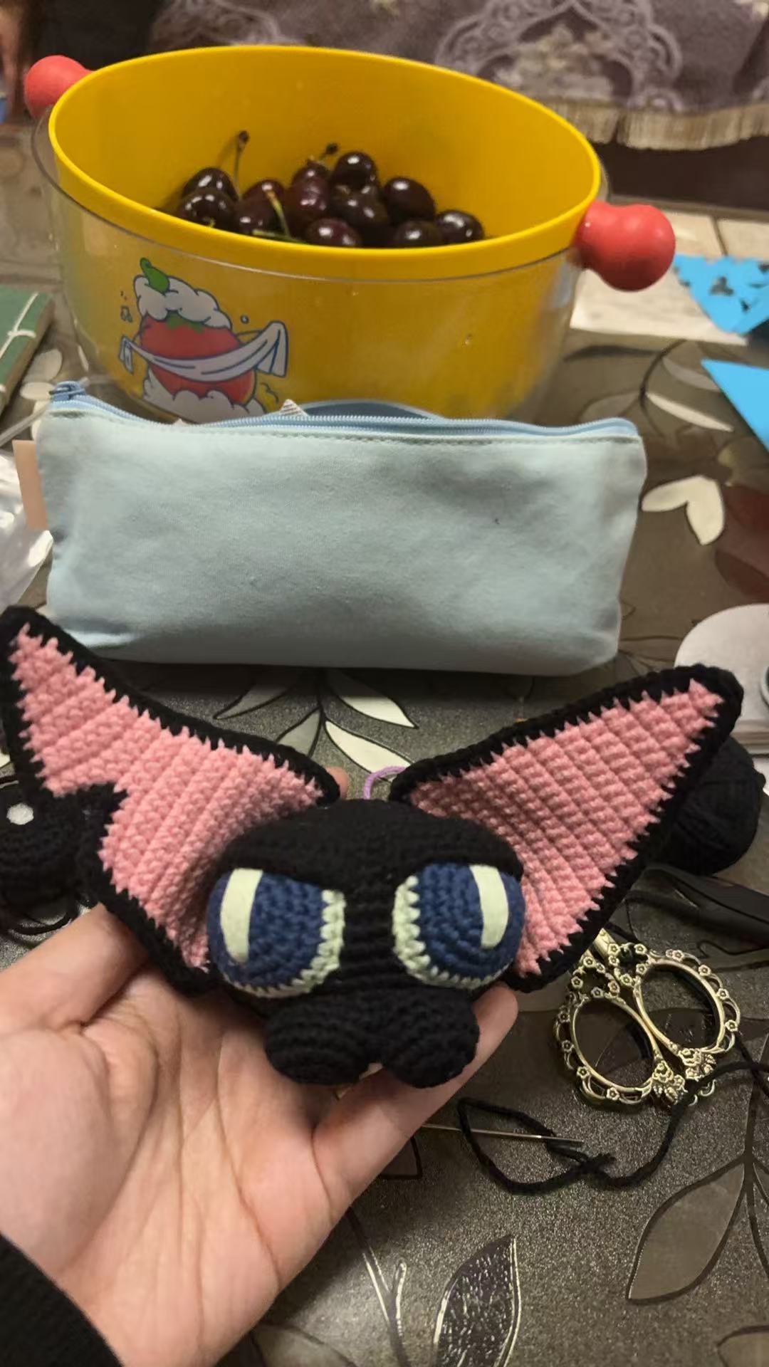Finished handmade crochet cat held in hand